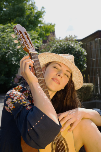 Photo Of Woman Holding Brown Guitar Photo Of Woman Holding Brown Guitar