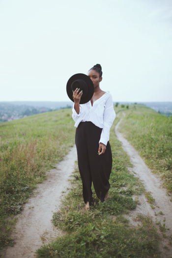 Photo of Woman Holding Her Hat Photo of Woman Holding Her Hat