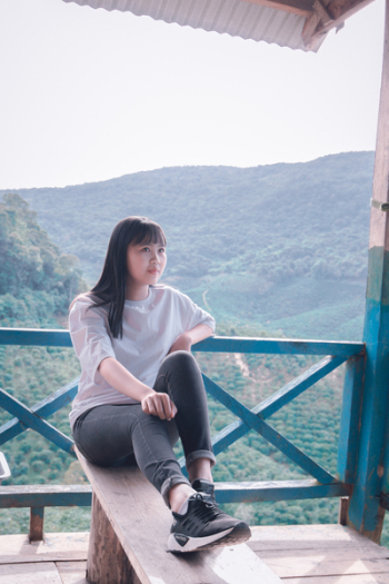 Photo of Woman Sitting on Wooden Bench Photo of Woman Sitting on Wooden Bench