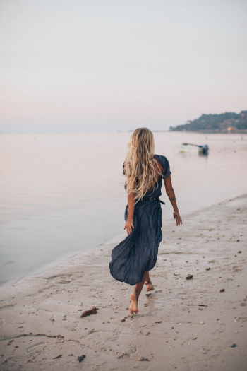 Photo of Woman Walking On Seashore Photo of Woman Walking On Seashore