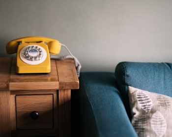 photo of yellow rotary telephone near blue sofa photo of yellow rotary telephone near blue sofa