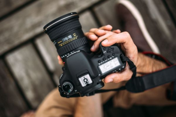 Photographer holding a DSLR camera Photographer holding a DSLR camera