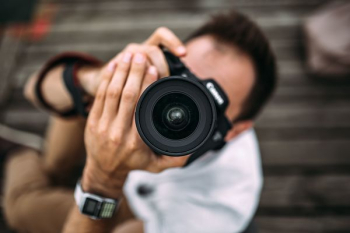 Photographer holding a DSLR camera Photographer holding a DSLR camera