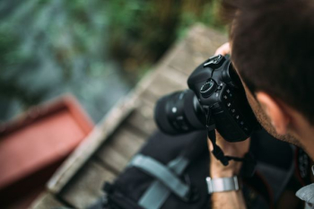 Photographer holding a DSLR camera Photographer holding a DSLR camera