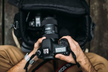 Photographer holding a DSLR camera Photographer holding a DSLR camera