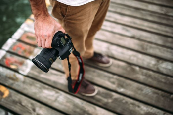 Photographer holding a DSLR camera Photographer holding a DSLR camera