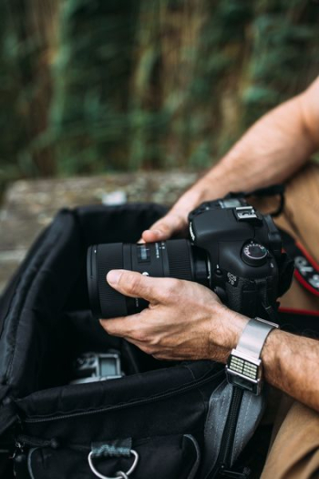 Photographer holding a DSLR camera Photographer holding a DSLR camera