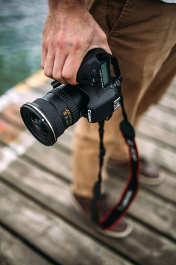Photographer holding a DSLR camera Photographer holding a DSLR camera