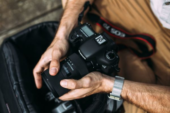 Photographer holding a DSLR camera Photographer holding a DSLR camera