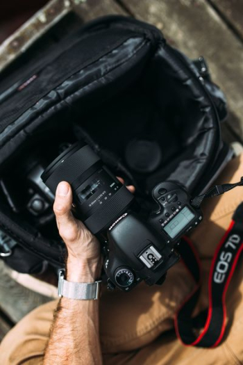 Photographer holding a DSLR camera Photographer holding a DSLR camera