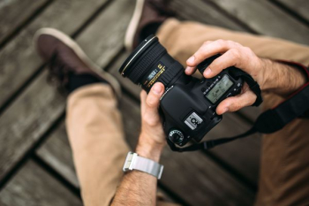 Photographer holding a DSLR camera Photographer holding a DSLR camera