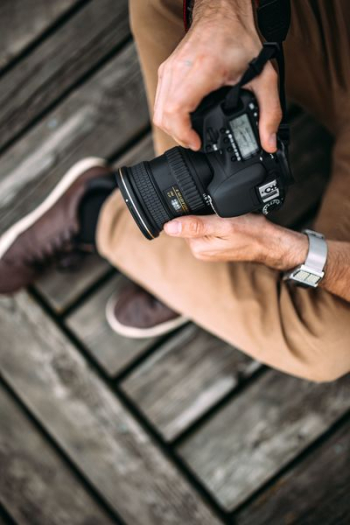 Photographer holding a DSLR camera Photographer holding a DSLR camera