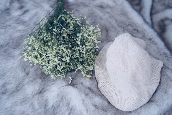Photography of White Hat Near White Flowers Photography of White Hat Near White Flowers