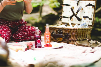 picnic basket beside two Ezze bottles on blanket picnic basket beside two Ezze bottles on blanket