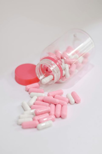 Pink and White Capsule Pills in a Container Pink and White Capsule Pills in a Container