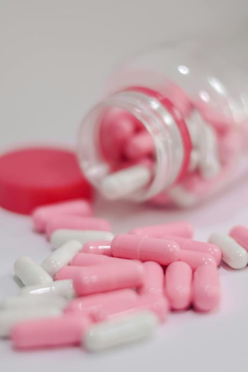 Pink and White Capsules in Open Bottle Pink and White Capsules in Open Bottle