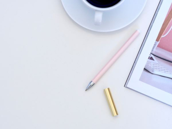 pink pen beside white ceramic teacup on white surface pink pen beside white ceramic teacup on white surface