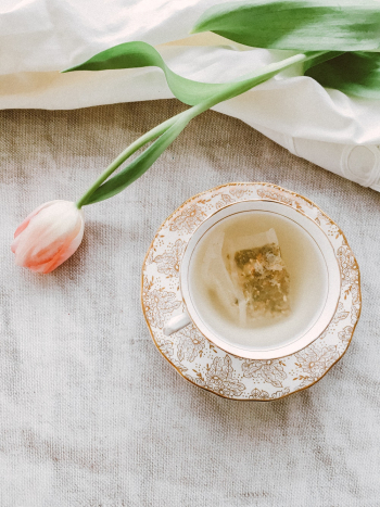 Pink-petaled Flowers Near Teacup and Saucer