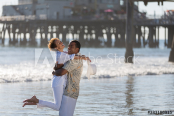 Playful active senior couple hugging on sunny ocean beach Playful active senior couple hugging on sunny ocean beach