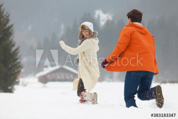 Playful young couple running in snow