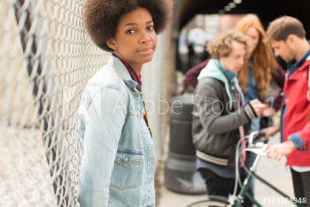 Portrait beautiful young woman with afro at chainlink fence Portrait beautiful young woman with afro at chainlink fence