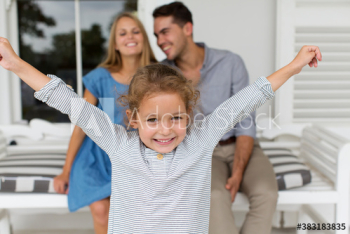 Portrait carefree girl with parents on patio