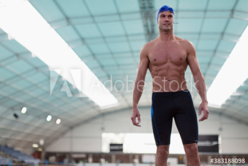 Portrait confident athletic male swimmer at indoors swimming pool