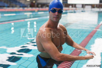 Portrait confident athletic male swimming in swimming pool