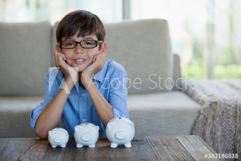 Portrait confident boy with piggybanks Portrait confident boy with piggybanks