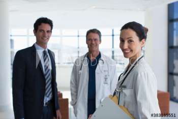 Portrait confident doctors and hospital administrator in lobby Portrait confident doctors and hospital administrator in lobby