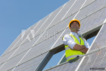 Portrait confident male engineer examining solar panels Portrait confident male engineer examining solar panels