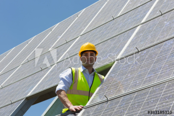 Portrait confident male engineer examining solar panels Portrait confident male engineer examining solar panels