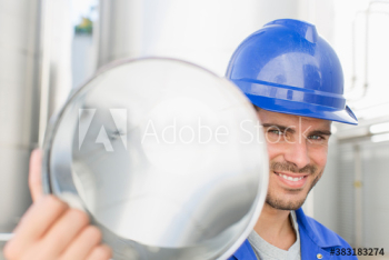 Portrait confident male worker carrying steel canister Portrait confident male worker carrying steel canister