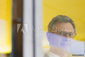 Portrait confident mature businessman at window Portrait confident mature businessman at window