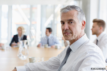 Portrait confident mature corporate businessman in meeting Portrait confident mature corporate businessman in meeting
