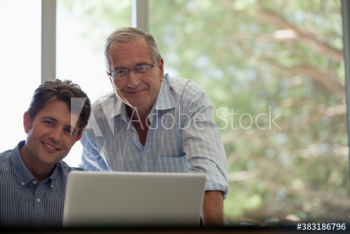 Portrait confident senior father and adult son at laptop Portrait confident senior father and adult son at laptop
