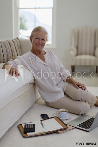 Portrait confident senior woman using laptop on living room floor Portrait confident senior woman using laptop on living room floor