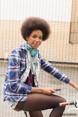 Portrait confident young woman with afro riding bicycle Portrait confident young woman with afro riding bicycle