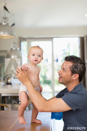 Portrait cute baby son and father at dining table Portrait cute baby son and father at dining table