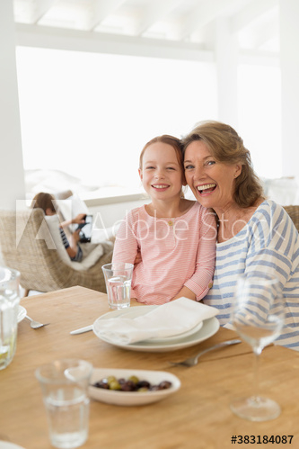 Portrait happy grandmother and granddaughter at table Portrait happy grandmother and granddaughter at table