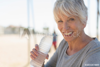 Portrait happy senior woman drinking cold bottled water Portrait happy senior woman drinking cold bottled water