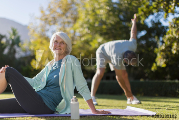 Portrait happy senior woman on yoga mat in sunny park Portrait happy senior woman on yoga mat in sunny park