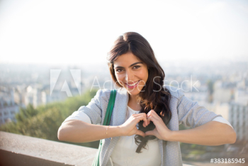 Portrait happy young woman gesturing heart-shape, Montmartre, Paris Portrait happy young woman gesturing heart-shape, Montmartre, Paris
