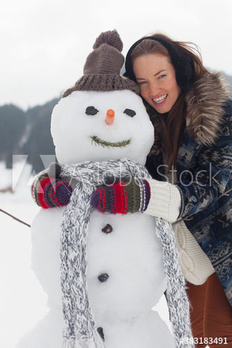 Portrait happy young woman hugging snowman Portrait happy young woman hugging snowman