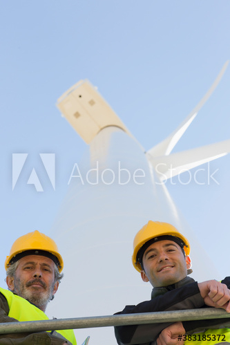 Portrait male engineers below wind turbine Portrait male engineers below wind turbine