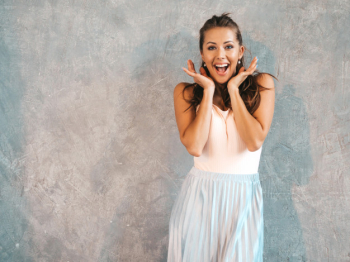 Portrait of young beautiful surprised woman looking  with hands near face. trendy girl in casual summer clothes. shocked female posing near gray wall Free Photo
