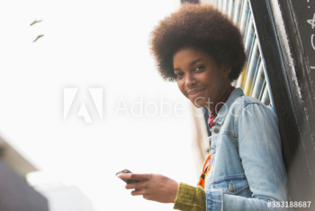 Portrait smiling beautiful young woman with afro using smart phone Portrait smiling beautiful young woman with afro using smart phone
