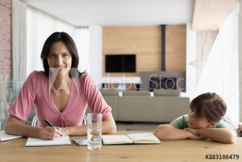 Portrait smiling mother working at dining table with daughter Portrait smiling mother working at dining table with daughter