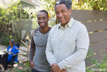 Portrait smiling senior father and adult sun on patio Portrait smiling senior father and adult sun on patio