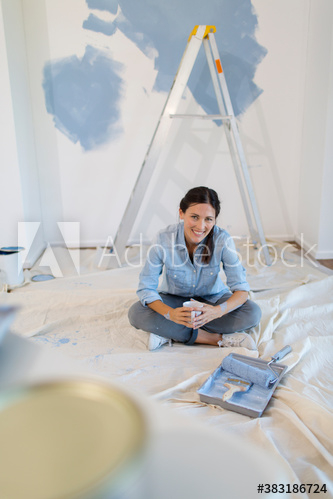 Portrait smiling woman painting room blue Portrait smiling woman painting room blue
